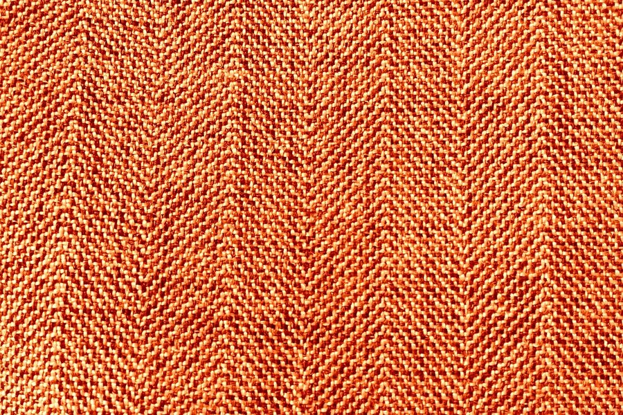 A close-up of a rust-coloured fabric weave.