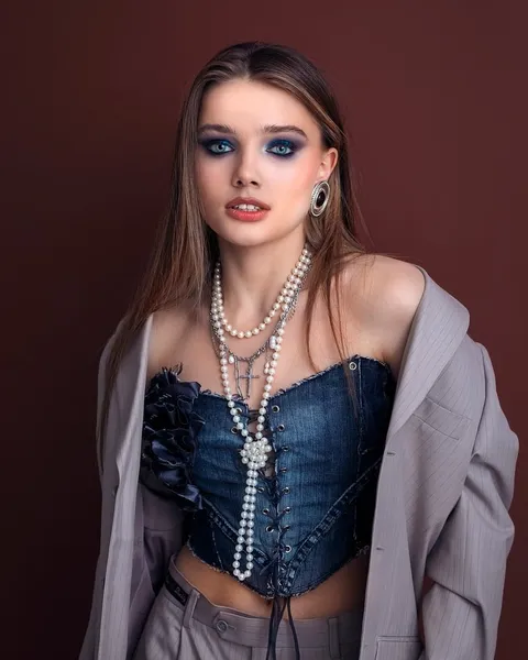 A woman in an open shirt over a cropped top.