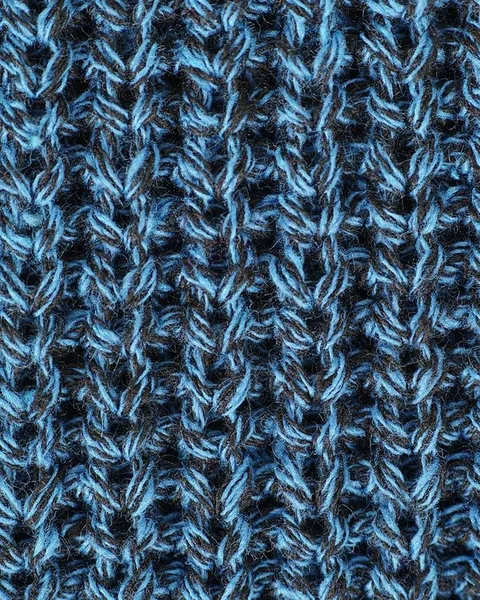 A macro photograph of blue knit stitches.