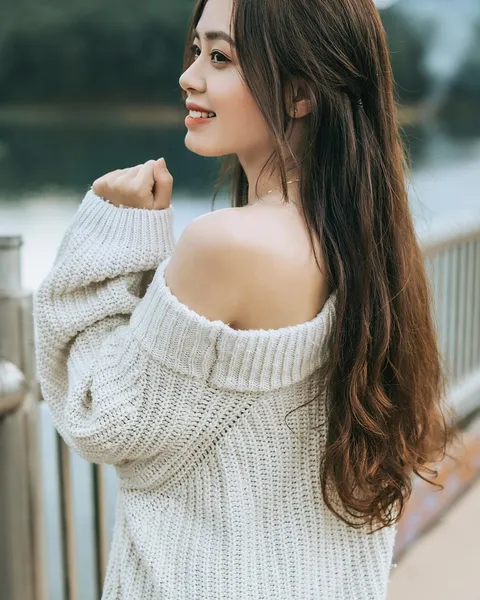 A woman in an off-shoulder cream knit.