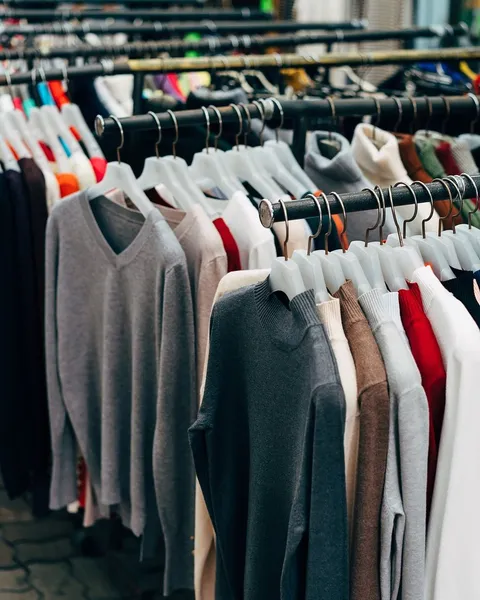 A rail of clothes in a bright room.