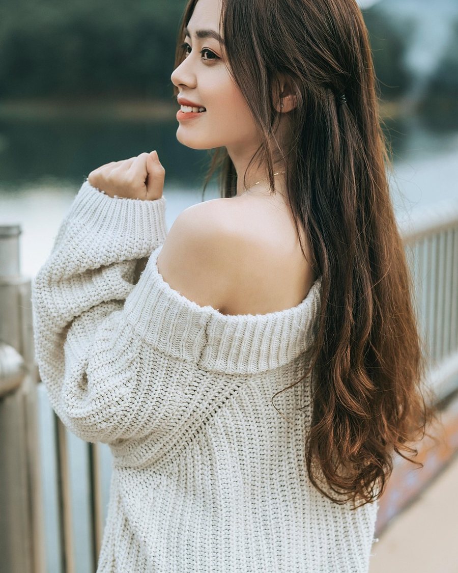 A woman in an off-shoulder cream knit.